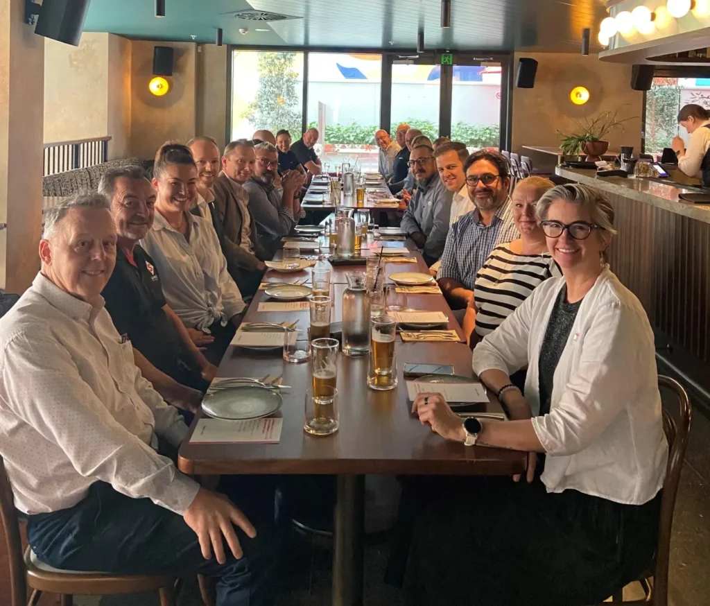 A group of people sitting around a long table at a restaurant